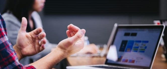 Reunión de trabajo con un cliente frente a una laptop
